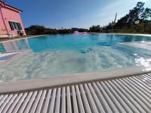 a large swimming pool with blue water at VILLA ROSA in Piazza