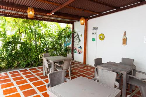 un patio con 2 mesas, sillas y plantas en Casa Colonial en Manga, en Cartagena de Indias