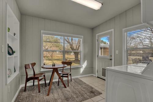 a kitchen with a table and chairs in a room at Luxury Mid Century Charmer Near Historic Main St in Fredericksburg