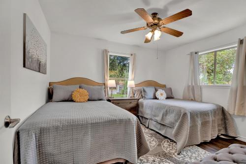 a bedroom with two beds and a ceiling fan at Luxury Haus - GREAT Backyard, Firepit, Bocce Ball! in Fredericksburg