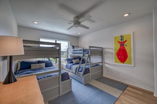a room with two bunk beds and a ceiling fan at Luxury Lakefront Home-Private Dock - Dipping Pool! in Spicewood