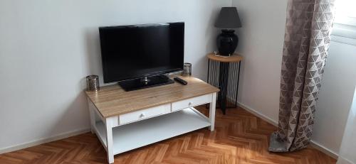 TV de pantalla plana en una mesa en una habitación en Appartement entier paisible proche Tours, en Joué-lès-Tours