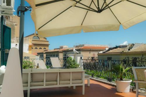 d'une terrasse avec un parasol sur le balcon. dans l'établissement Terrazza Massimo, à Palerme