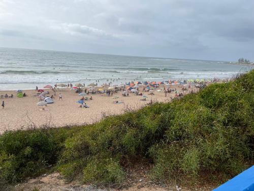 a crowd of people on a beach with umbrellas at Sidi Bouzid Ground floor with garden and swim pool see view in Sidi Bouzid