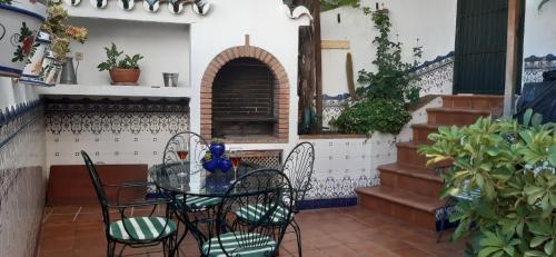 Casa Luciíta: Agradable con chimenea, patio y BBQ. في أُوخين: طاولة وكراسي في فناء مع موقد