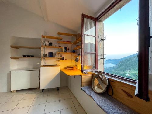 La cuisine est équipée d'une fenêtre, d'un évier et d'un réfrigérateur. dans l'établissement Studio Sainte Agnès, à Sainte-Agnès