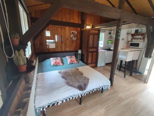 a bedroom with a large bed in a house at La baraque des artistes in Laharie