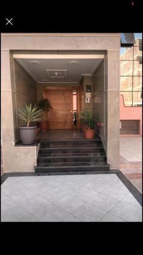 a building with stairs and potted plants in front of a door at MTL residence in Oujda