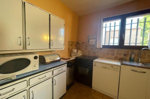 une cuisine avec des armoires blanches et un micro-ondes dans l'établissement Nice nest in downtown Caves, à Caves