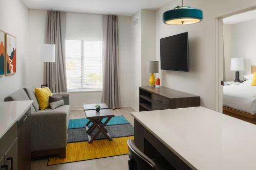 a hotel room with a bed and a living room at WaterWalk Extended Stay by Wyndham Jacksonville Deerwood Pk in Jacksonville