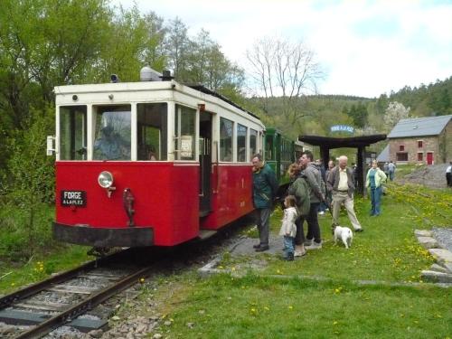 a group of people standing next to a red train at ziggy's room with a view in Heyd