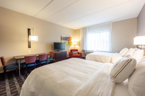 a hotel room with two beds and a table and chairs at TownePlace Suites by Marriott Front Royal in Front Royal