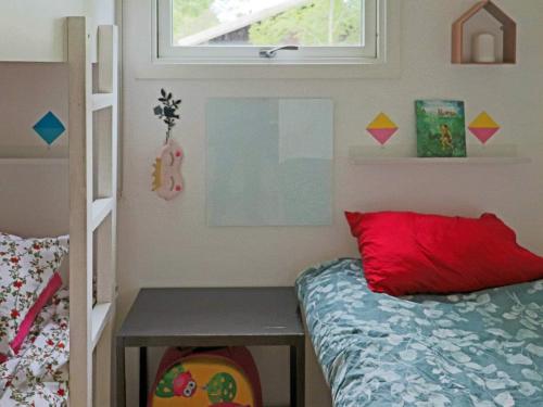 a bedroom with a bed and a desk next to a window at Holiday home STENINGE in Steninge