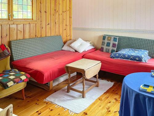 Cette chambre comprend 2 lits et une table. dans l'établissement Holiday home KOLMÅRDEN, à Kolmården