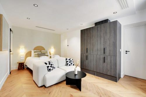 - une chambre avec un lit blanc et un canapé blanc dans l'établissement Brand New Modern Studio in Central Paris - 2P - B4, à Paris