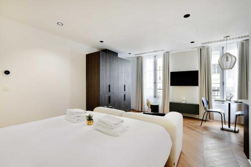 - une chambre blanche avec un lit blanc et une salle à manger dans l'établissement Brand New Modern Studio in Central Paris - 2P - B4, à Paris