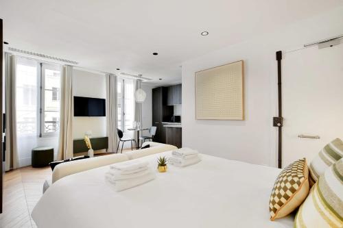 - une chambre blanche avec un grand lit et un salon dans l'établissement Brand New Modern Studio in Central Paris - 2P - B4, à Paris