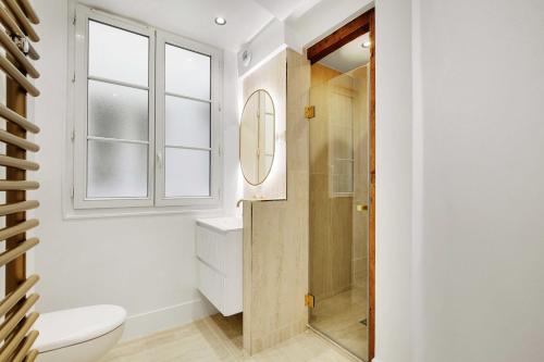 La salle de bains est pourvue d'une douche, de toilettes et d'une fenêtre. dans l'établissement Brand New Modern Studio in Central Paris - 2P - B4, à Paris