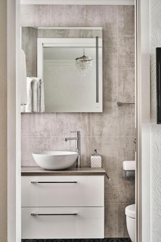 une salle de bain avec un lavabo et un miroir dans l'établissement Bekkjarvik Gjestgiveri, à Bekkjarvik