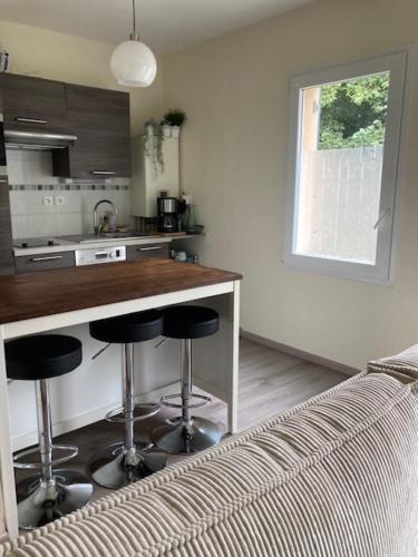 - une cuisine avec un comptoir et des tabourets de bar dans l'établissement Studio 10min SAINT-MALO, à Saint-Méloir-des-Ondes