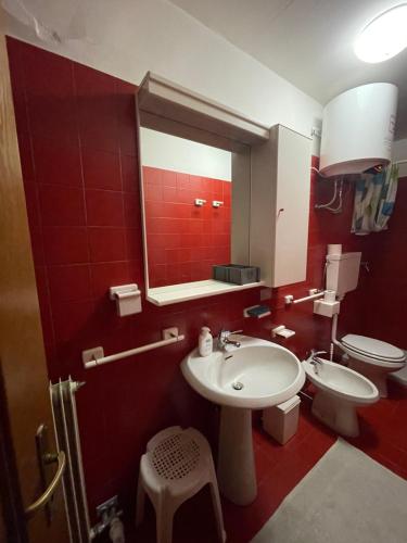 a bathroom with a sink and a toilet and a mirror at La casa di Pianca 2.0 in Piancavallo