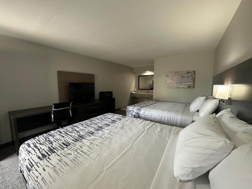 a hotel room with two beds and a desk at Budget Inn Muskogee in Muskogee