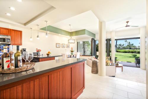 an open kitchen and living room with a view of the yard at Mauna Lani Point in Waikoloa