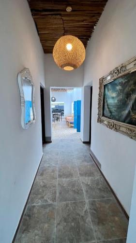 a hallway with a painting on the wall and a chandelier at Wadi Shab Beach House in Ramlah
