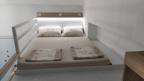 uma cama com duas almofadas num quarto em Cozy Gallery - City Centre em Novi Sad