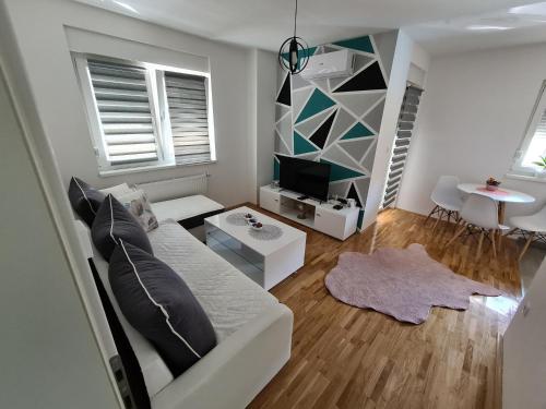 a living room with a white couch and a tv at Apartman CRYSTAL in Brčko
