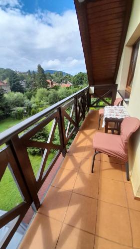 a balcony with a table and chairs and a view at Willa Gracja in Wisła