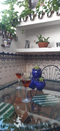 dos copas de vino sentadas en una mesa de cristal en Casa Luciíta: Agradable con chimenea, patio y BBQ. en Ojén