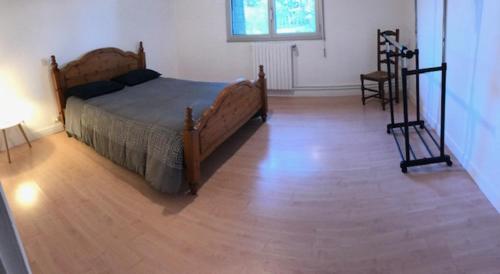 une chambre avec un lit et un parquet dans l'établissement Le Moulin de Crampaux, à Mansigné