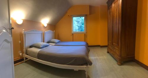 une chambre avec un lit et une fenêtre dans l'établissement Le Moulin de Crampaux, à Mansigné