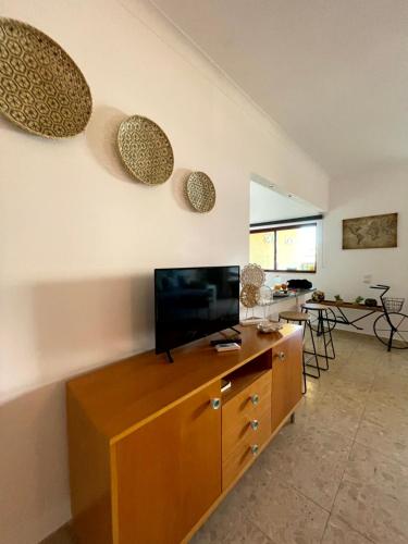 uma sala de estar com televisão num armário de madeira em Estrela do Mar II em Portimão