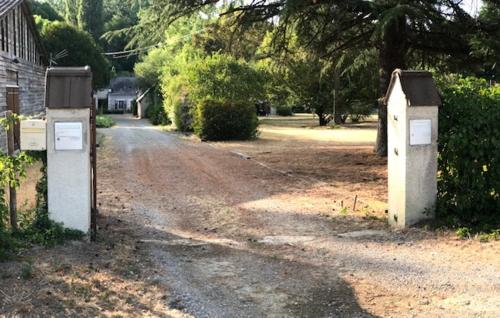 a dirt road with two mail boxes in a yard at Le Moulin de Crampaux in Mansigné