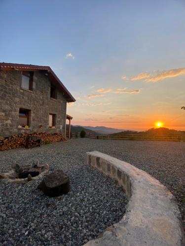 a stone house with the sunset in the background at AXÂRA VİLLA SUİT in Pazar
