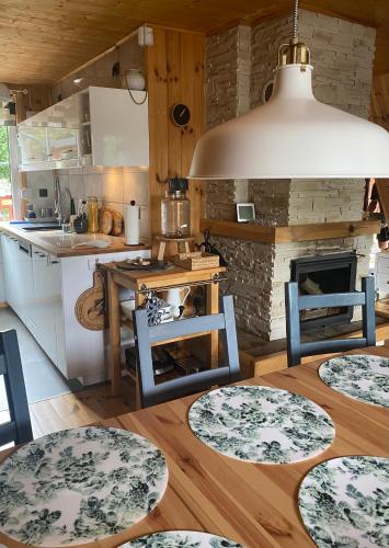 a kitchen with blue chairs and a table with a fireplace at Kamień na Kaszubach in Kamień