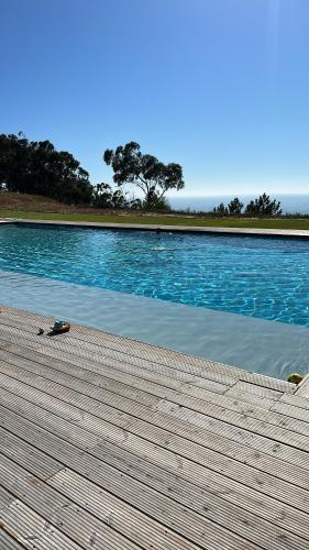 a large swimming pool with a wooden boardwalk next to it at Atlantic view in Nazaré