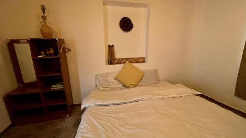 a small room with a bed with a pillow on it at Wadi Shab Beach House in Ramlah