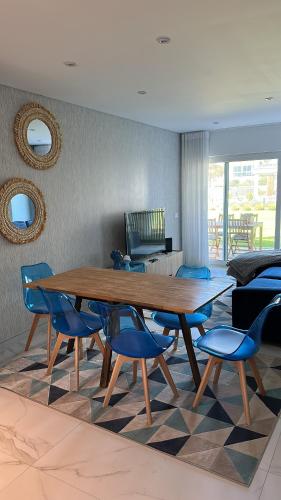 a dining room with a wooden table and blue chairs at Atlantic view in Nazaré