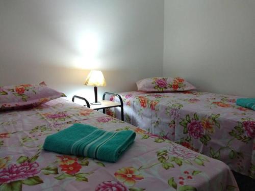 2 letti posti uno accanto all'altro in una stanza di Lindo Apartamento na Praia do Sonho a Itanhaém