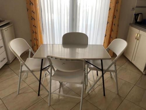 uma mesa branca e cadeiras numa cozinha em Nafija No1 em Donji Stoj