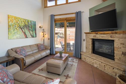 een woonkamer met een bank en een open haard bij Coyote Run #2 - Stunning Views in Moab