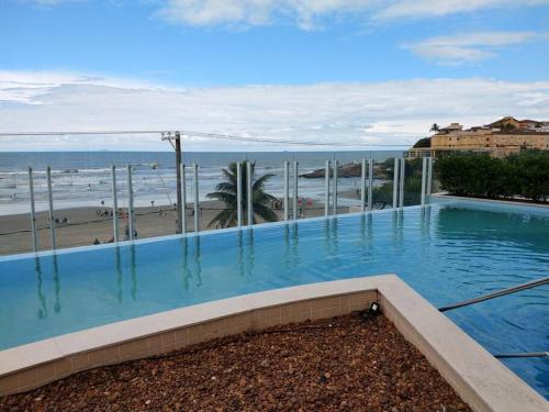 una piscina con vista sulla spiaggia di Lindo Apartamento na Praia do Sonho a Itanhaém