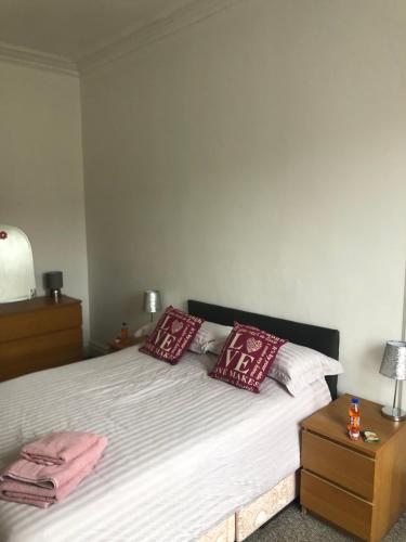 1 dormitorio con 1 cama con almohadas rojas y blancas en Olivia Meadowview Penthouse, en Edimburgo