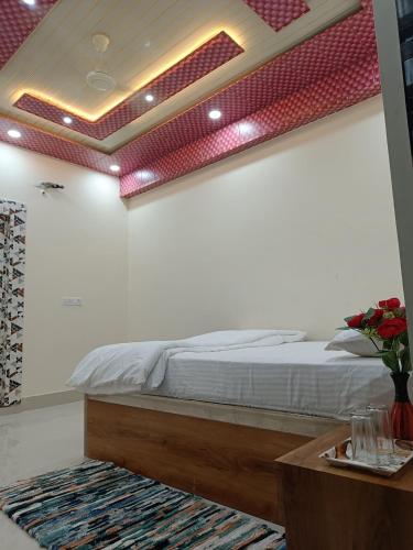 a bedroom with a bed and a table with flowers on it at The Royal Sahdeo Venue in Gaya