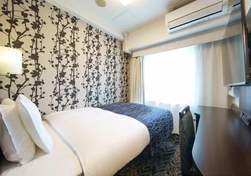 ein Hotelzimmer mit einem Bett und einem Fenster in der Unterkunft APA Hotel Osaka Tanimachi Yonchome-Ekimae in Osaka