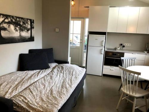 a bedroom with a bed and a table and a kitchen at Adorable one bedroom apartment with free parking. in Reykjavík