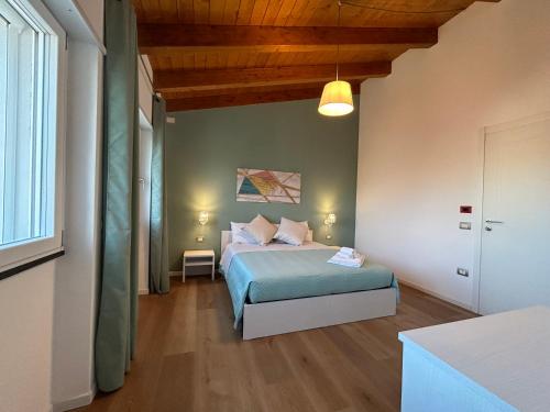 a bedroom with a bed and a large window at Ferdinando’s House in Pozzomaggiore